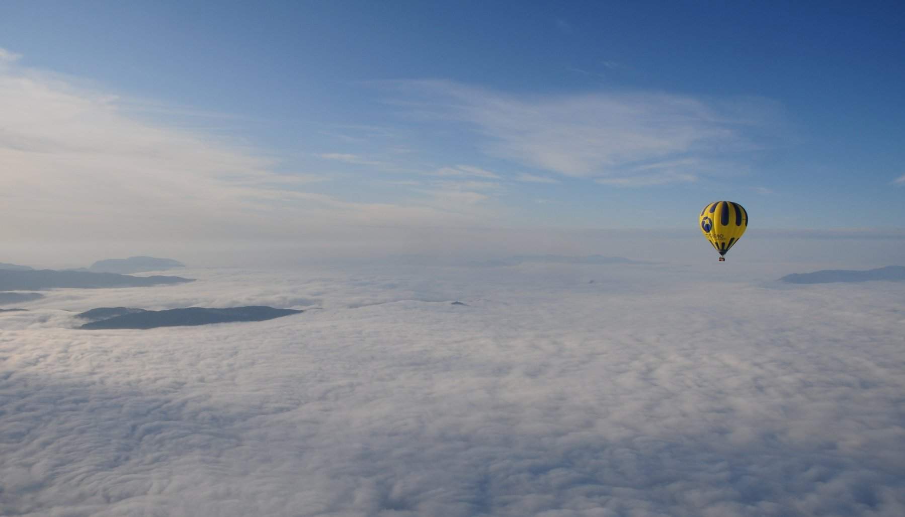 Globo de Totglobo volando sobre un mar de nubes al amanecer