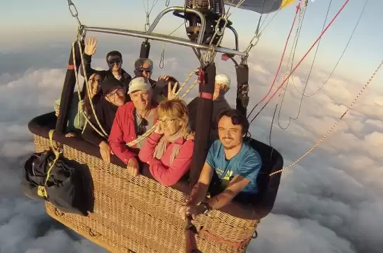 Pasajeros saludando desde la cesta del globo